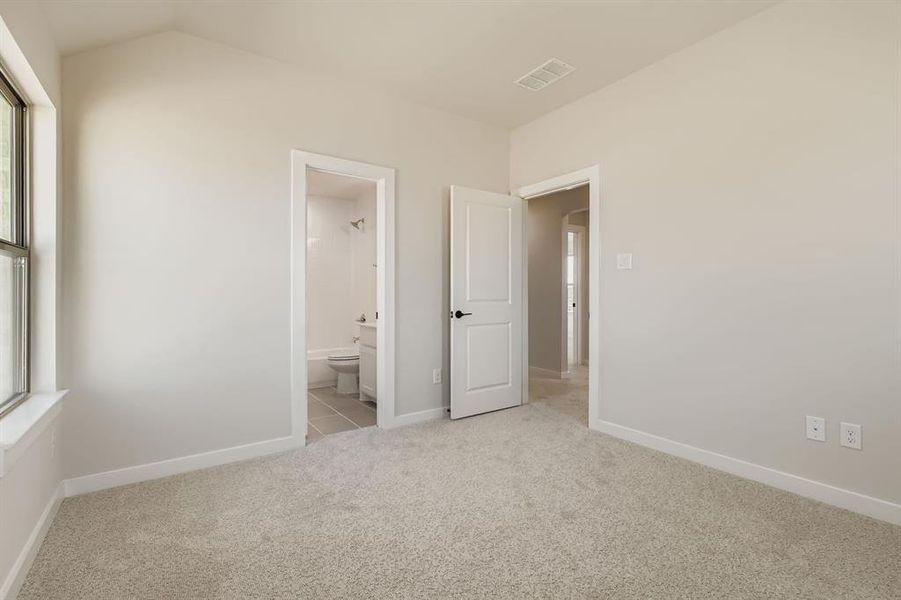 Unfurnished bedroom with carpet flooring and ensuite bath