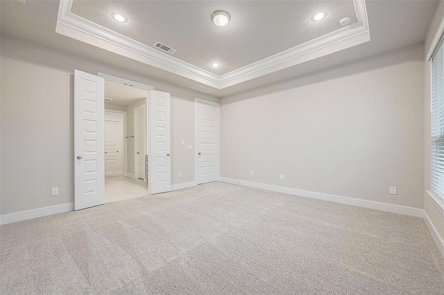 Double doors enter into a primary bathroom with double vanities, oversized shower, and freestanding tub.