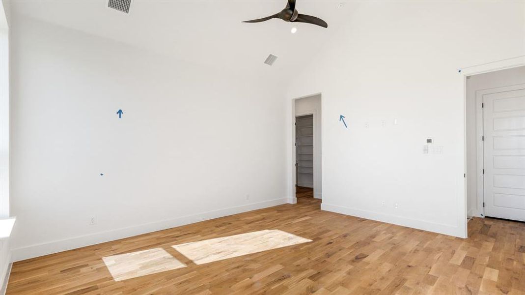 Empty room with light hardwood / wood-style floors and high vaulted ceiling