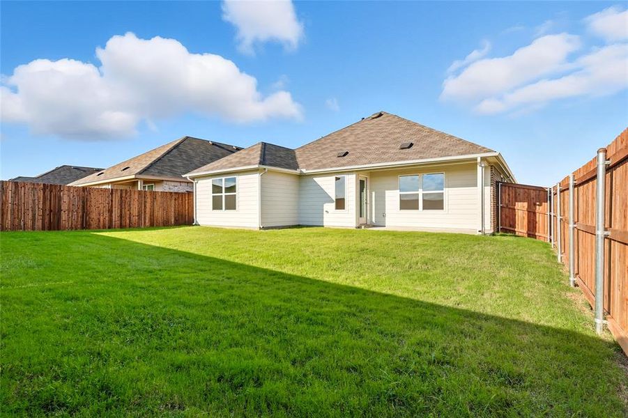 Back of house featuring a fenced backyard and roof with shingles Back of house featuring a fenced backyard and roof with shingles