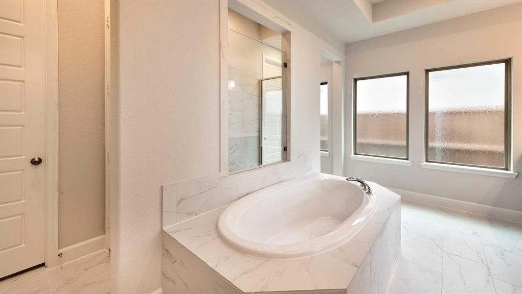 Bathroom featuring tile patterned flooring and tiled bath