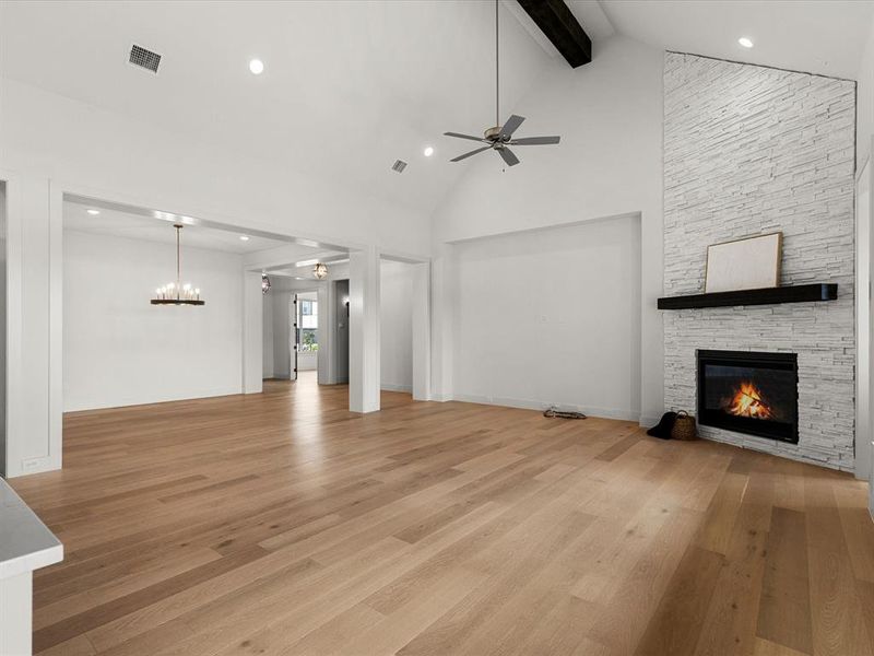 Unfurnished living room featuring light wood-type flooring, recessed lighting, beamed ceiling, a fireplace, and a ceiling fan Unfurnished living room featuring light wood-type flooring, recessed lighting, beamed ceiling, a fireplace, and a ceiling fan