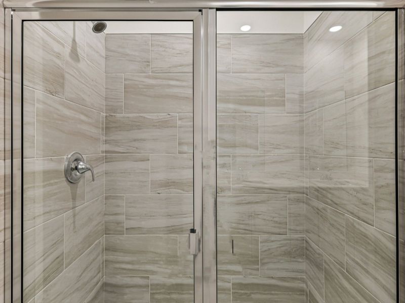 The primary bathroom offers dual vanity sinks and a walk-in shower.