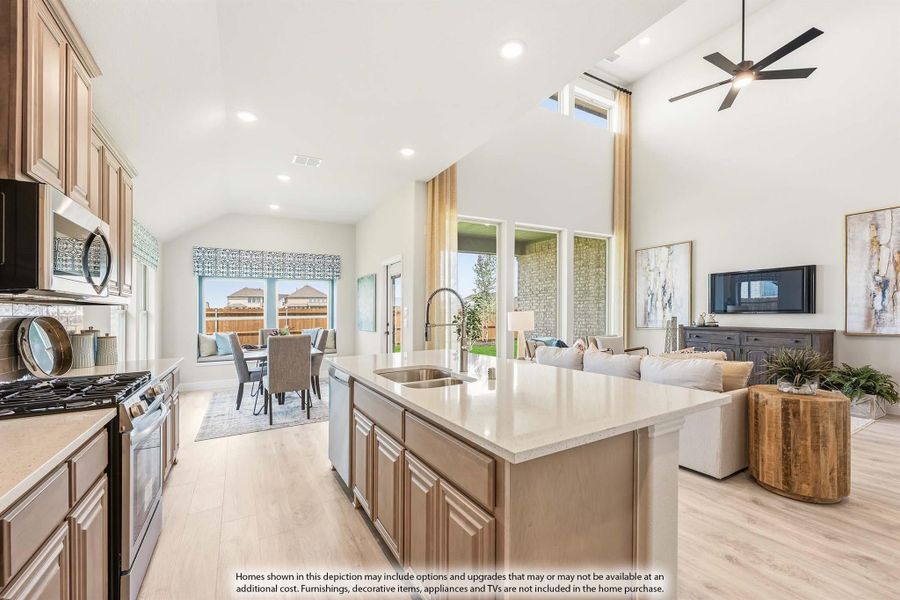 Open-concept kitchen with large island, vaulted ceiling, and views into dining and living areas with hardwood floors