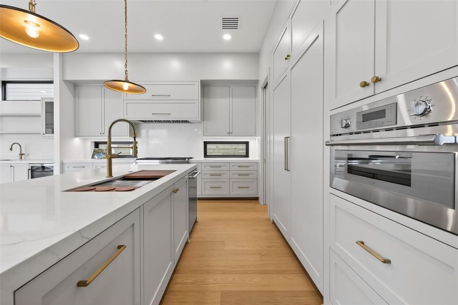 Spacious kitchen with stainless steel appliances and modern waterfall island.