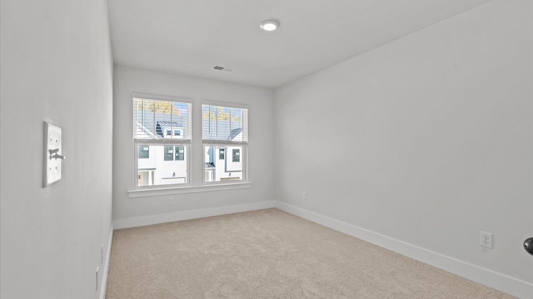 Notable secondary bedroom offering cozy carpeted flooring and a stylish walk-in closet