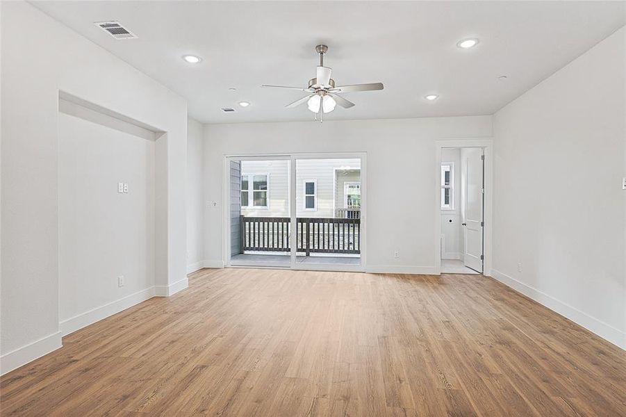 Empty room with ceiling fan, light wood finished floors, and recessed lighting
