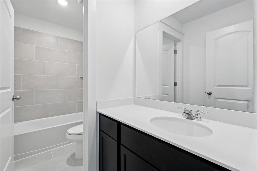 Bathroom featuring vanity, shower / bathtub combination, recessed lighting, and light tile patterned flooring Bathroom featuring vanity, shower / bathtub combination, recessed lighting, and light tile patterned flooring