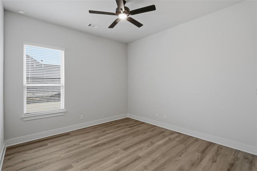 Empty room with light wood-type flooring and a ceiling fan