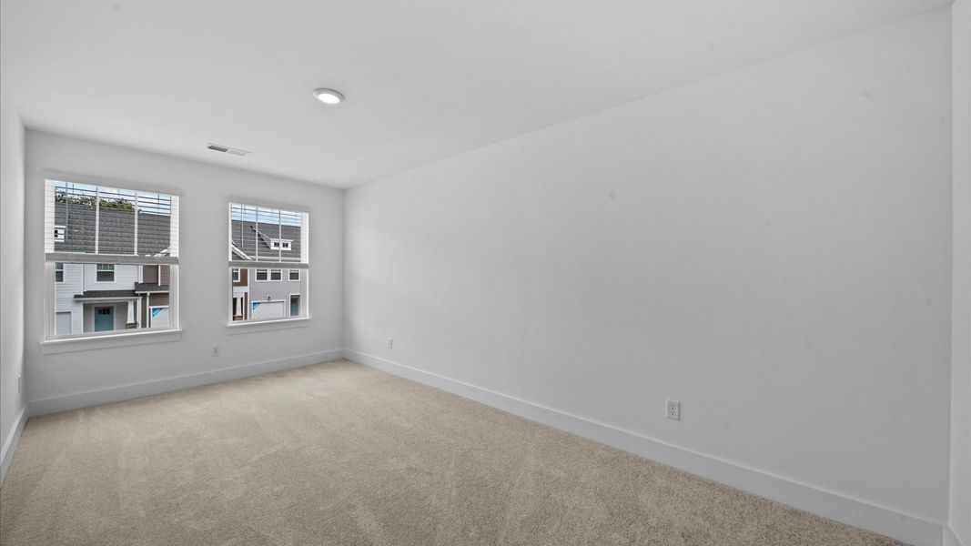 Tasteful bedroom with plush carpet, a walk-in closet, and large windows for abundant natural light in Spartanburg, SC