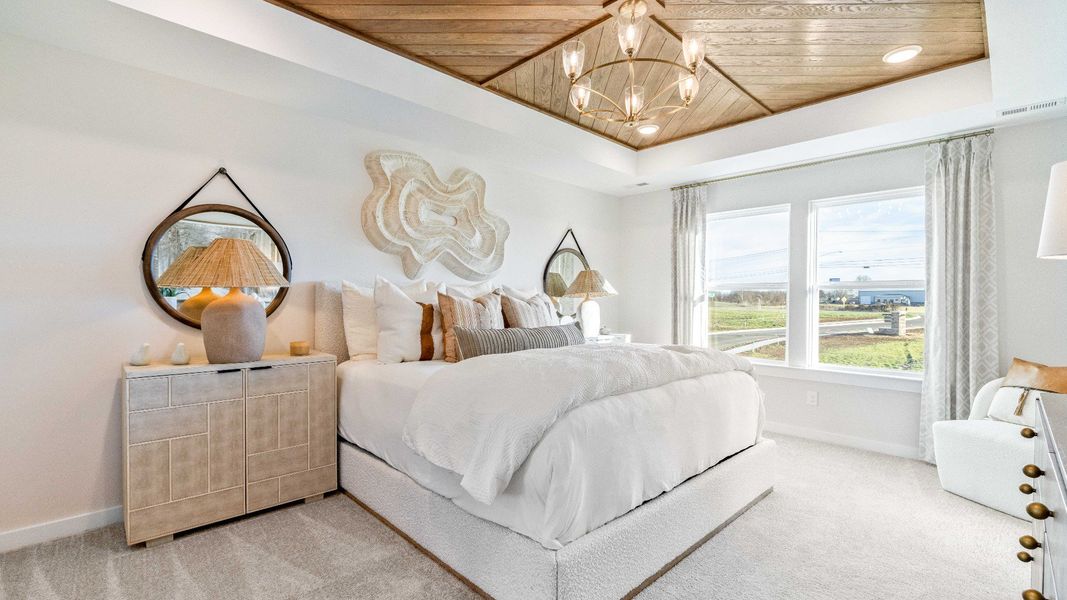 Large decorated primary bedroom with design upgrades
