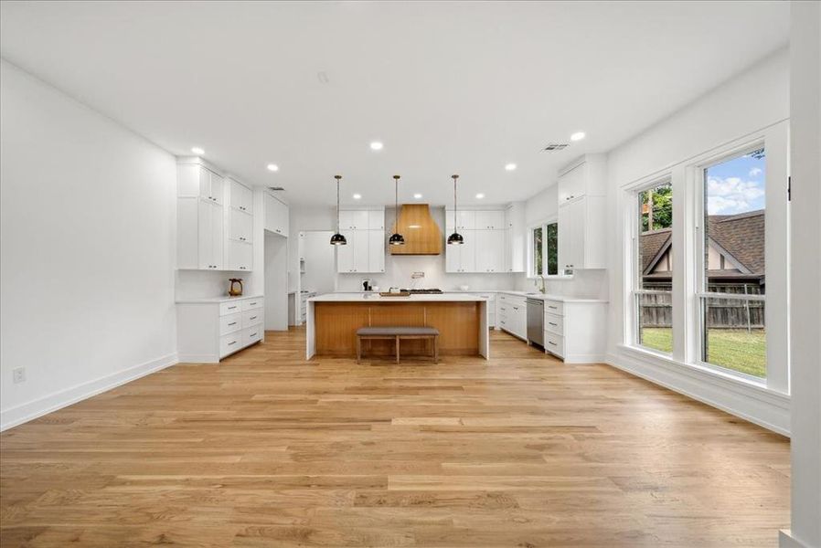 Kitchen featuring white cabinetry, a center island, and decorative light fixtures