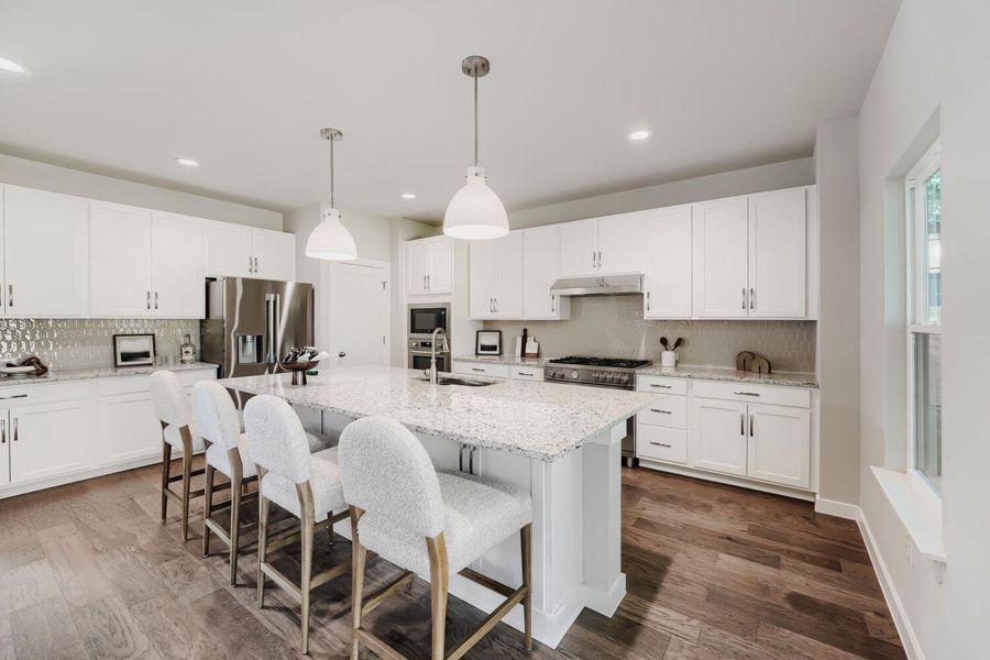 Culinary delights await in this bright kitchen with an inviting central island and high-end stainless steel appliances. Culinary delights await in this bright kitchen with an inviting central island and high-end stainless steel appliances.