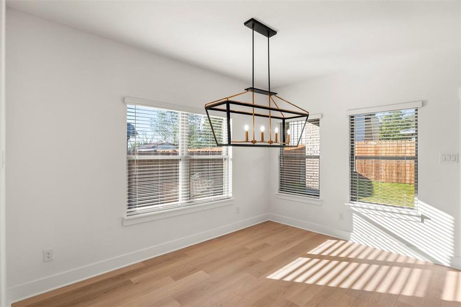 Unfurnished dining area with light wood-style floors and a chandelier