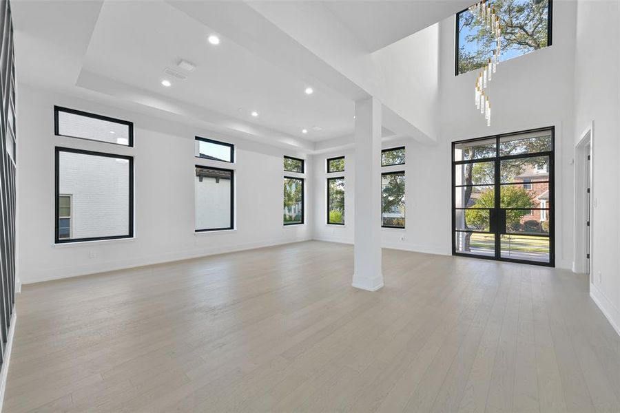 The two story entry is accented by the luxurious chandelier and is illuminated with natural light from the large transom window and glass front door.