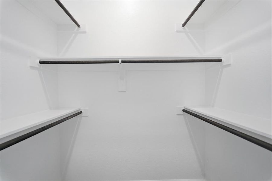 White-painted closet interior featuring multiple shelving units and clothing rods