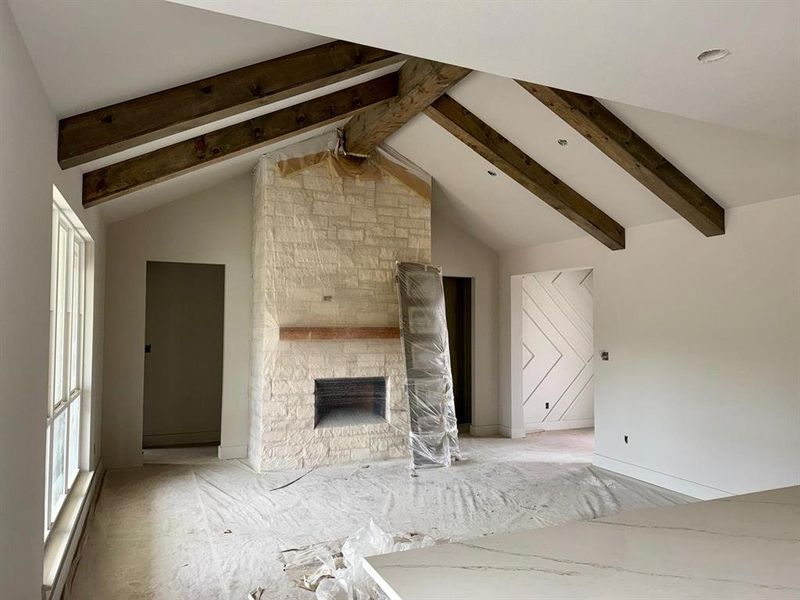 Unfurnished living room with a stone fireplace and baseboards Unfurnished living room with a stone fireplace and baseboards