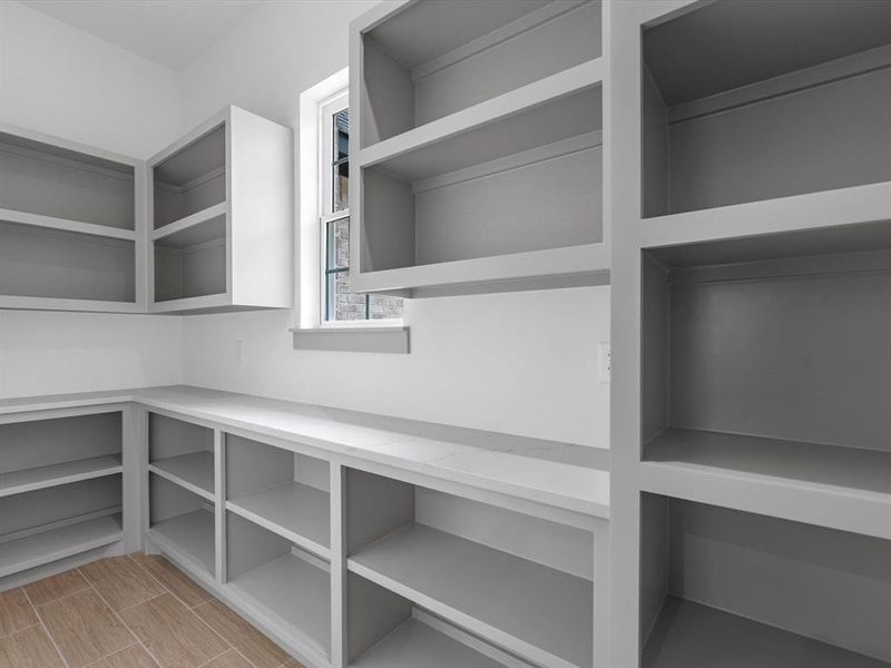 This kitchen features a hidden walk in pantry next to the fridge