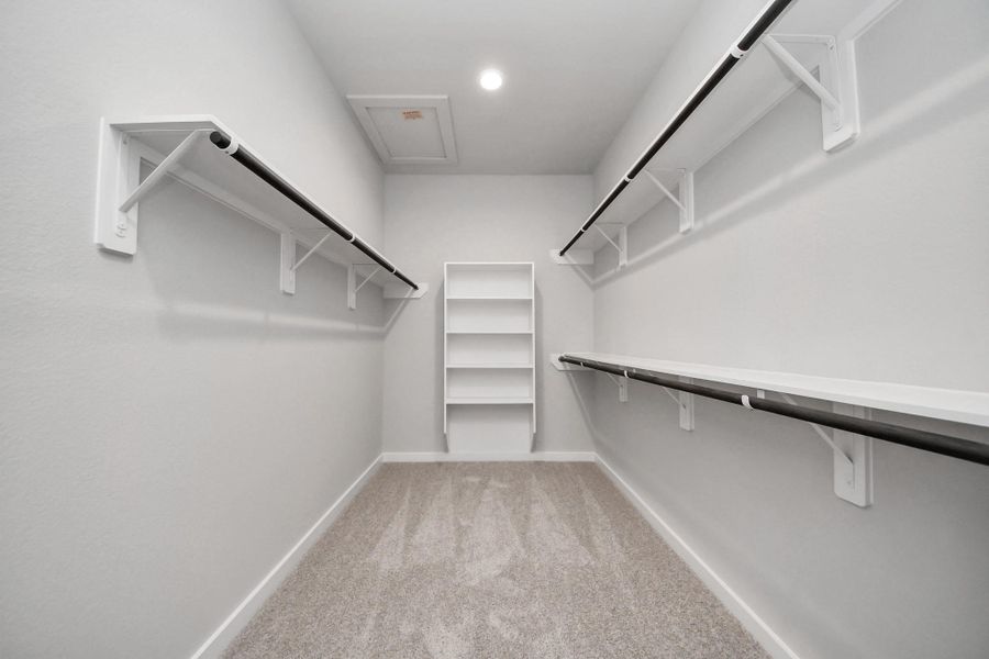 Walk-in closet that epitomizes luxury and practicality. This generously sized space features built-in shelving, offering abundant room for impeccable organization. High ceilings and recessed lighting create a bright and welcoming ambiance.