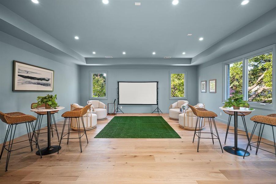 Playroom with light wood-type flooring and golf simulator