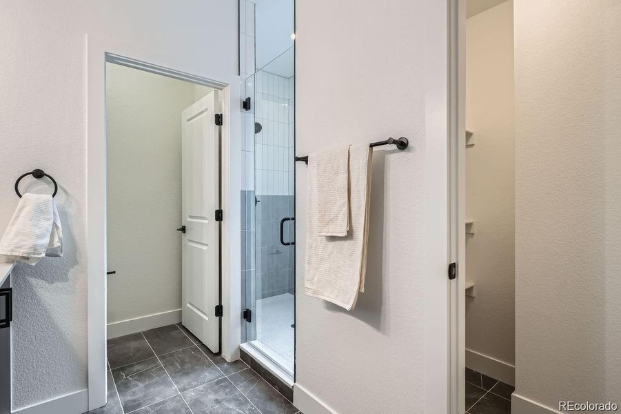 Primary bathroom with spacious shower, private water closet, and extra storage closet.