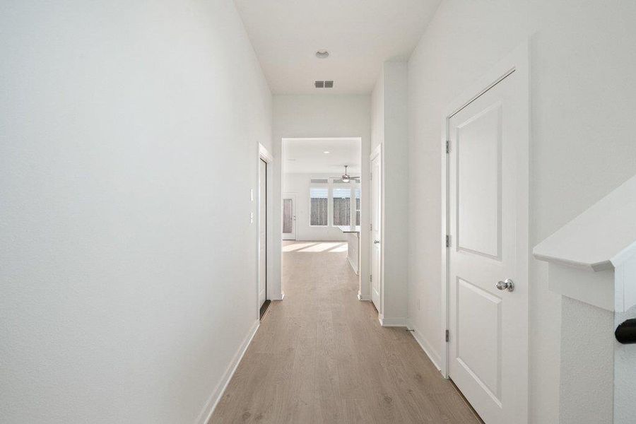 Hall with light wood-style floors and baseboards