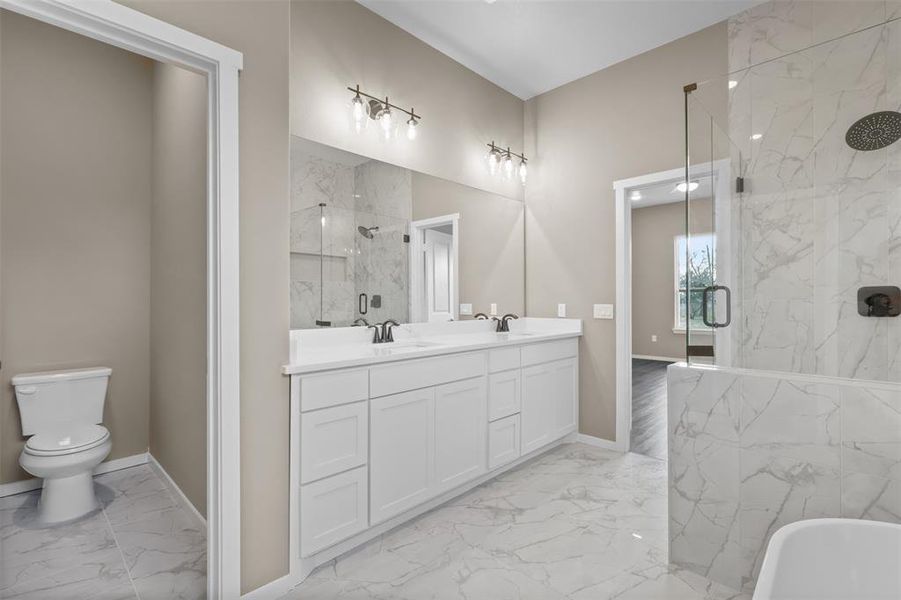 Full bathroom featuring vanity, toilet, and separate shower and tub