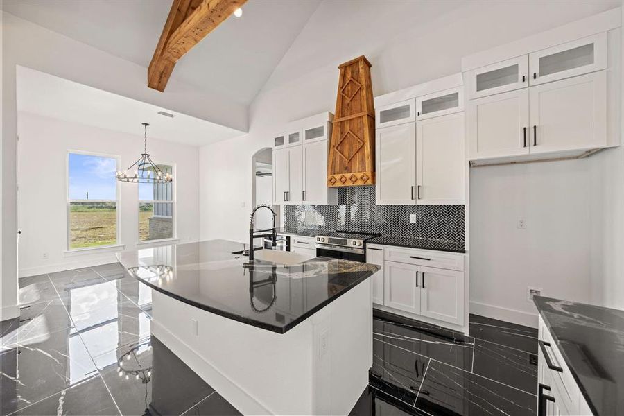 Kitchen featuring glass insert cabinets, tasteful backsplash, white cabinets, pendant lighting, and beamed ceiling Kitchen featuring glass insert cabinets, tasteful backsplash, white cabinets, pendant lighting, and beamed ceiling