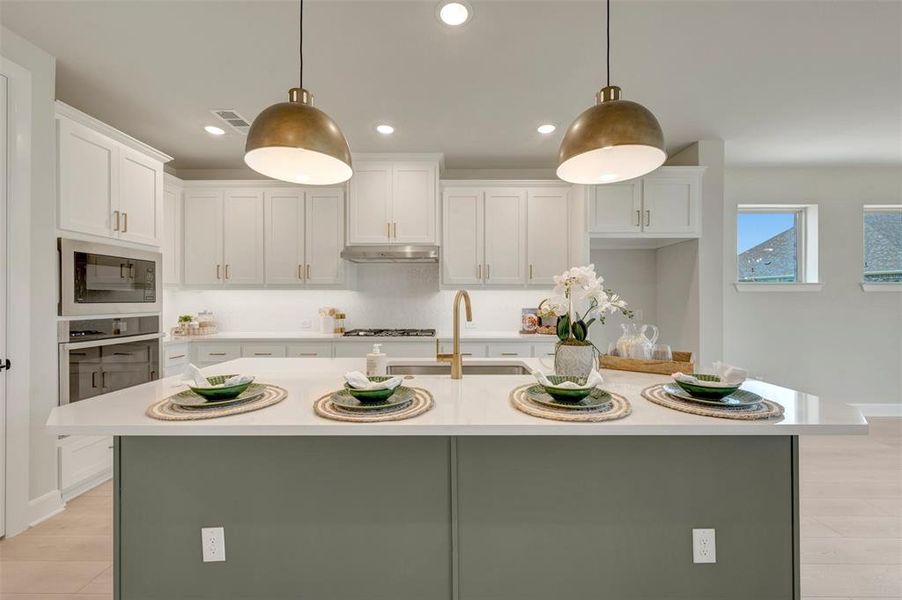 Kitchen featuring a center island, white cabinetry, integrated stainless-steel appliances, recessed lighting, and wood-finish flooring