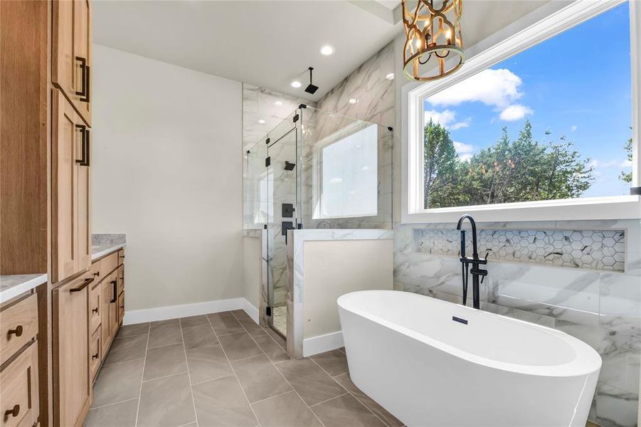 Bathroom featuring vanity, a freestanding tub, a marble finish shower, recessed lighting, and light tile patterned floors