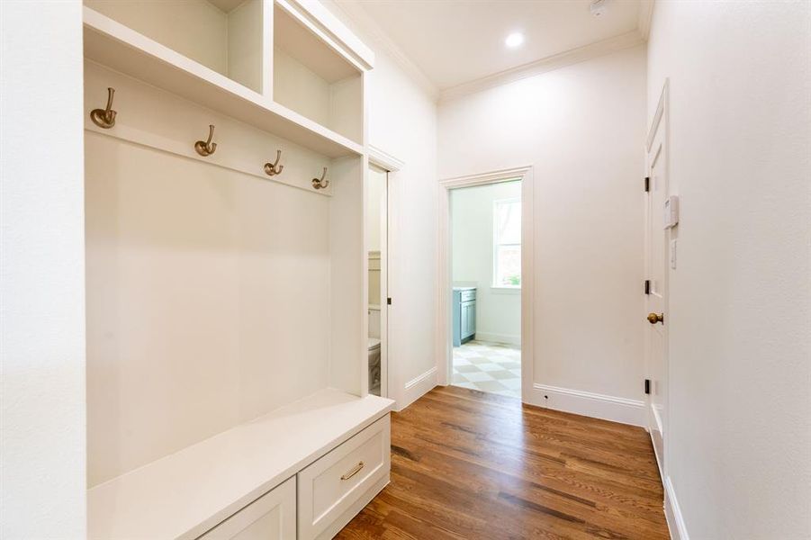 Entryway featuring custom built-in storage with a bench, drawers, and upper shelving Entryway featuring custom built-in storage with a bench, drawers, and upper shelving