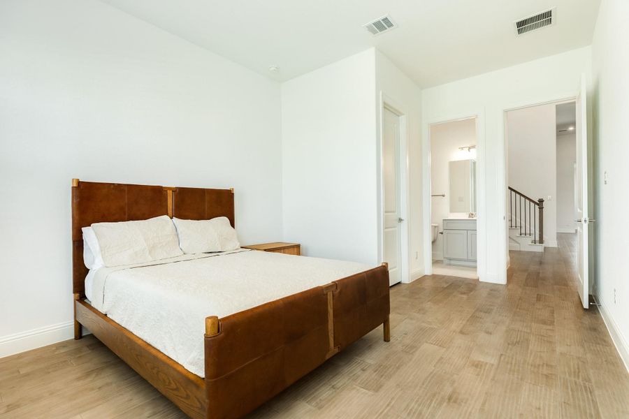The guest ensuite is situated at the front of the home, providing enhanced privacy, and features a spacious closet, a private bathroom, and elegant hardwood flooring.