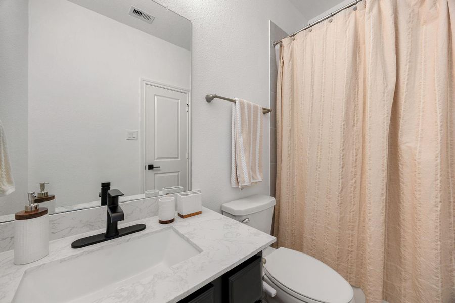 The secondary bathroom features a modern vanity, tub/shower combination, and neutral finishes.