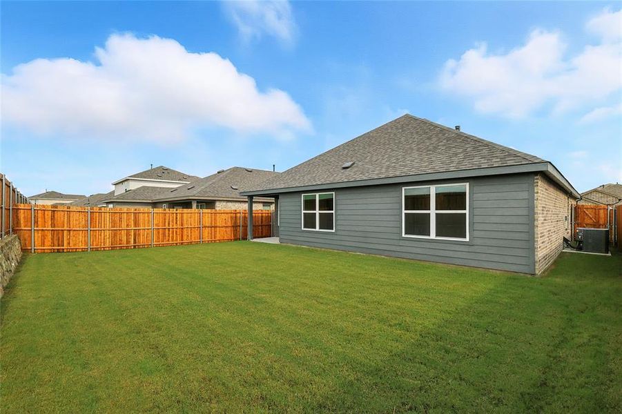 Rear view of house with a fenced backyard, a patio, and roof with shingles Rear view of house with a fenced backyard, a patio, and roof with shingles