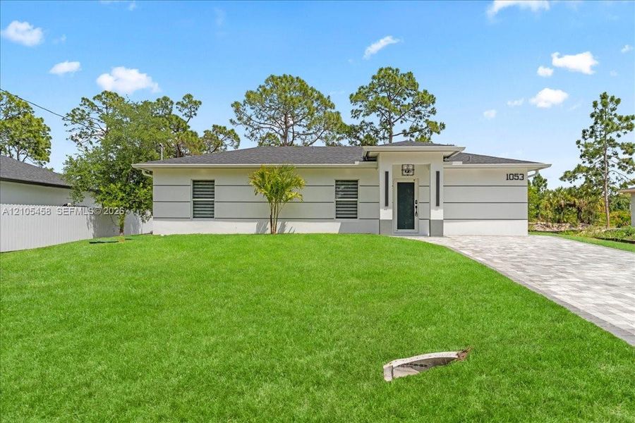 Contemporary-style exterior with a clean white and gray palette, dark entry door, and a paved driveway Contemporary-style exterior with a clean white and gray palette, dark entry door, and a paved driveway
