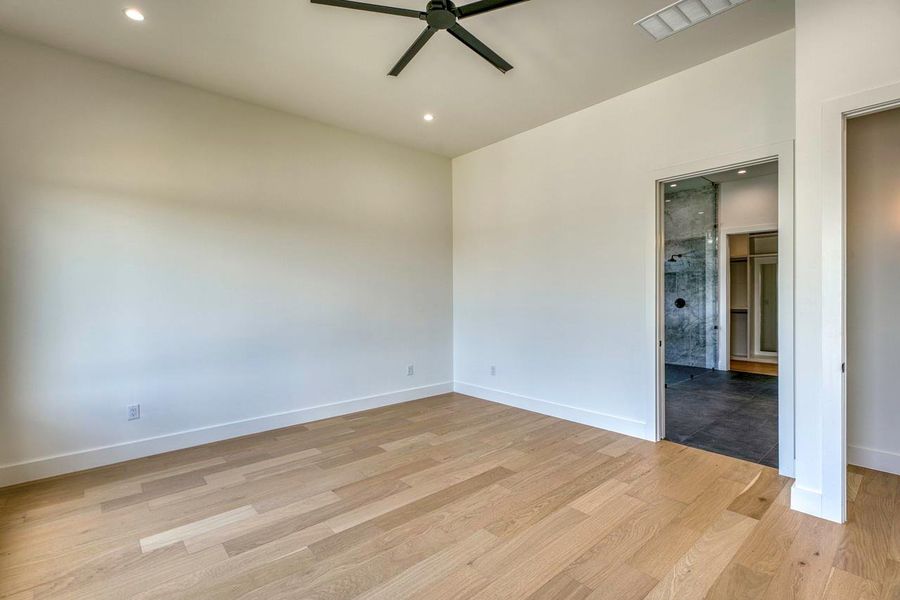 Gleaming hardwood floors run through this airy bedroom with direct access to an en suite bath.
