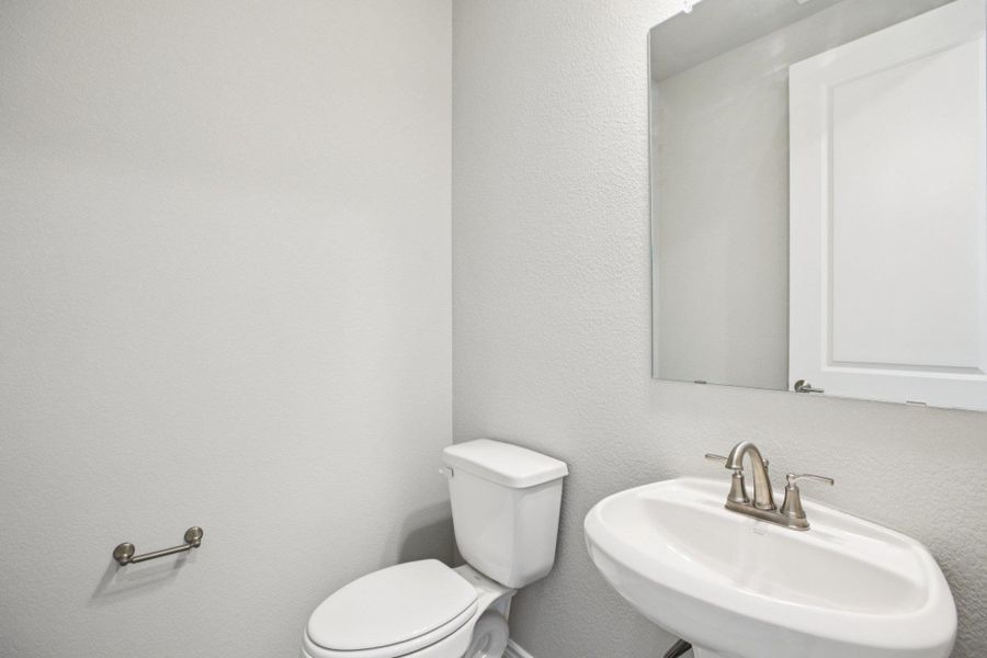Bathroom featuring a textured wall and a sink