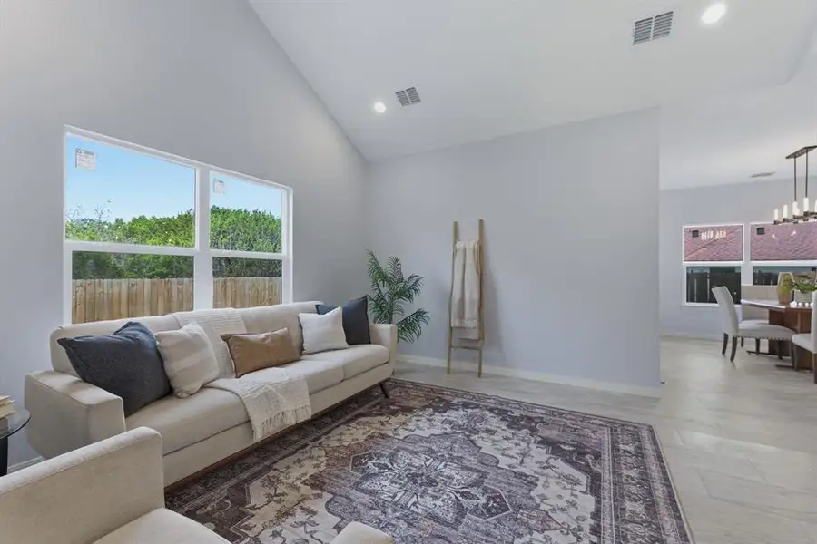 Living area with lofted ceiling, healthy amount of natural light, and a chandelier Living area with lofted ceiling, healthy amount of natural light, and a chandelier