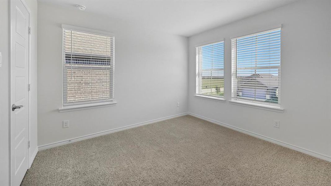 Unfurnished room featuring light carpet and plenty of natural light