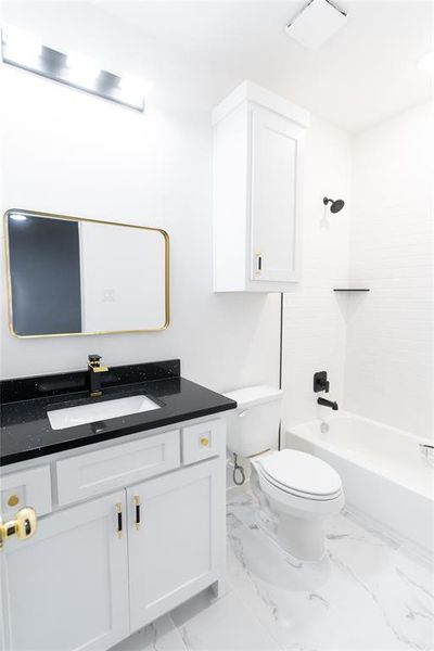 Bathroom with tub / shower combination, toilet, vanity, and marble finish floor Bathroom with tub / shower combination, toilet, vanity, and marble finish floor
