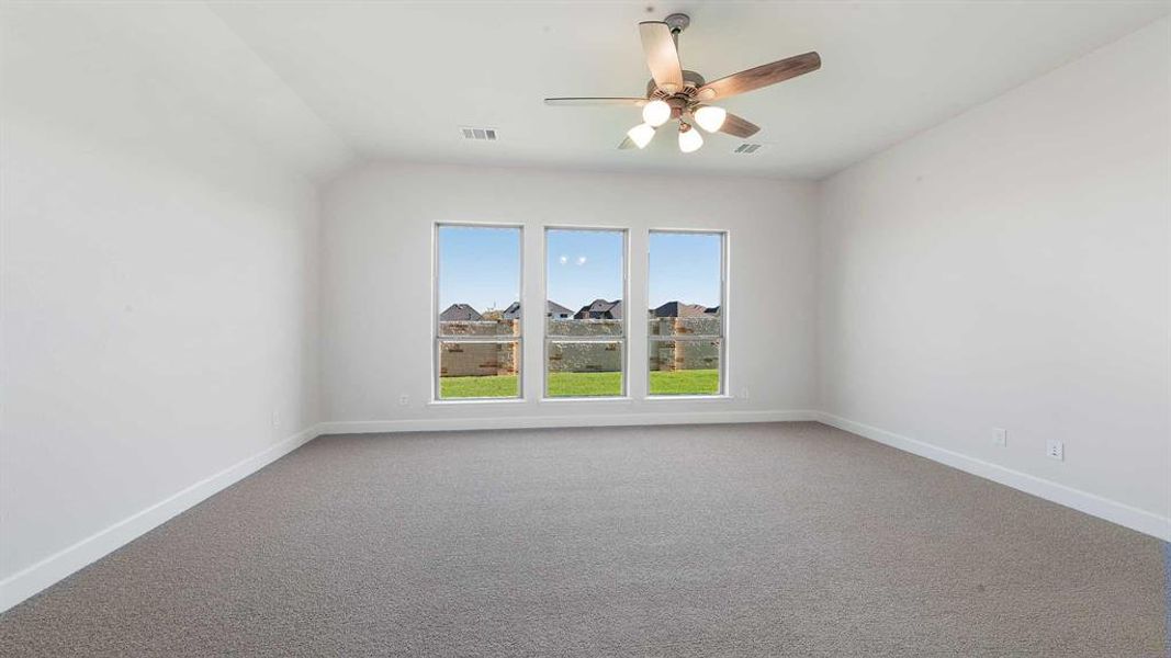 Spare room with carpet flooring, ceiling fan, and lofted ceiling