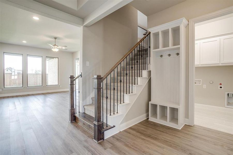 Staircase featuring ceiling fan and hardwood / wood-style floors