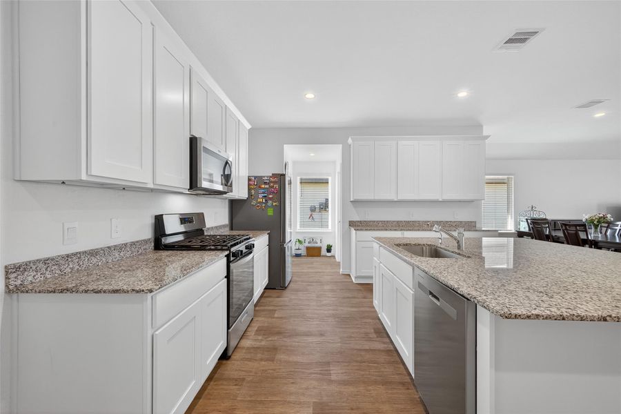 A chef’s kitchen boasting granite surfaces, custom cabinetry, and premium stainless steel appliances.