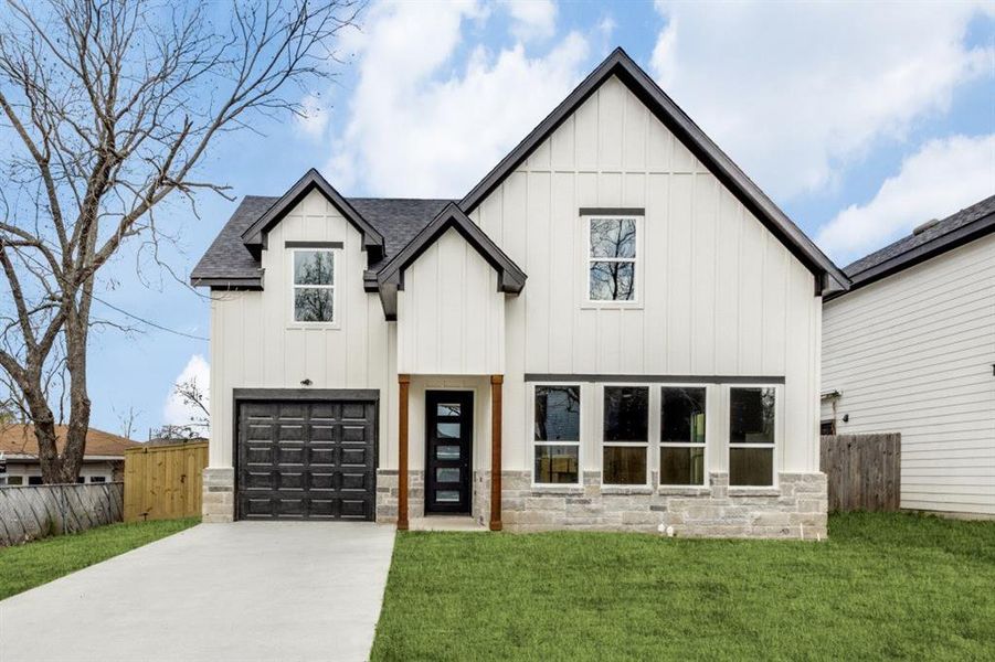 Modern farmhouse featuring a front lawn and a garage