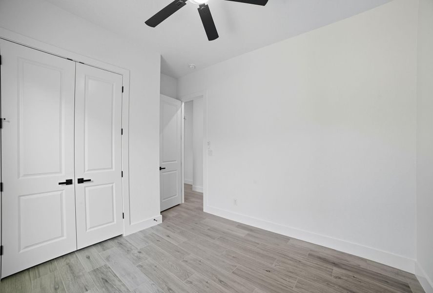 Unfurnished bedroom with light wood-style floors, a closet, and ceiling fan Unfurnished bedroom with light wood-style floors, a closet, and ceiling fan