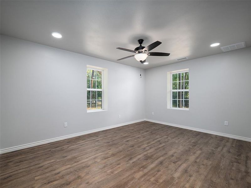 Unfurnished room featuring dark wood-style floors, recessed lighting, plenty of natural light, and ceiling fan