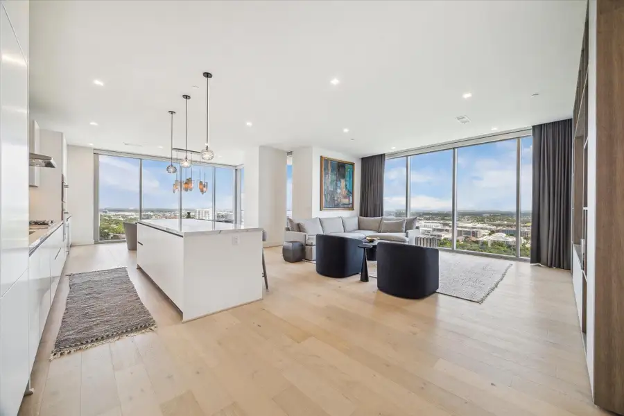 Remote controlled shades cover all the windows and custom draperies add warmth to the feel of the open space.