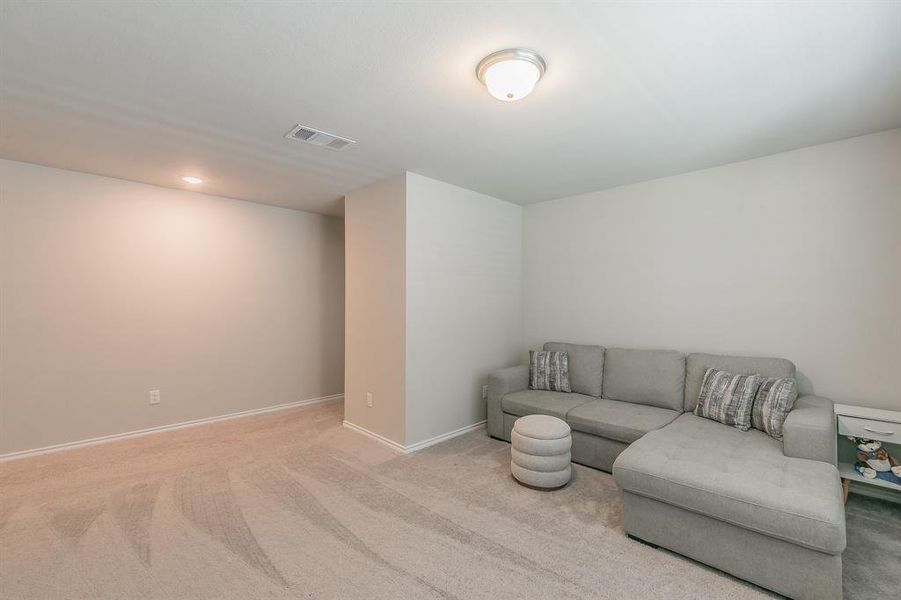 Carpeted living area featuring baseboards and recessed lighting