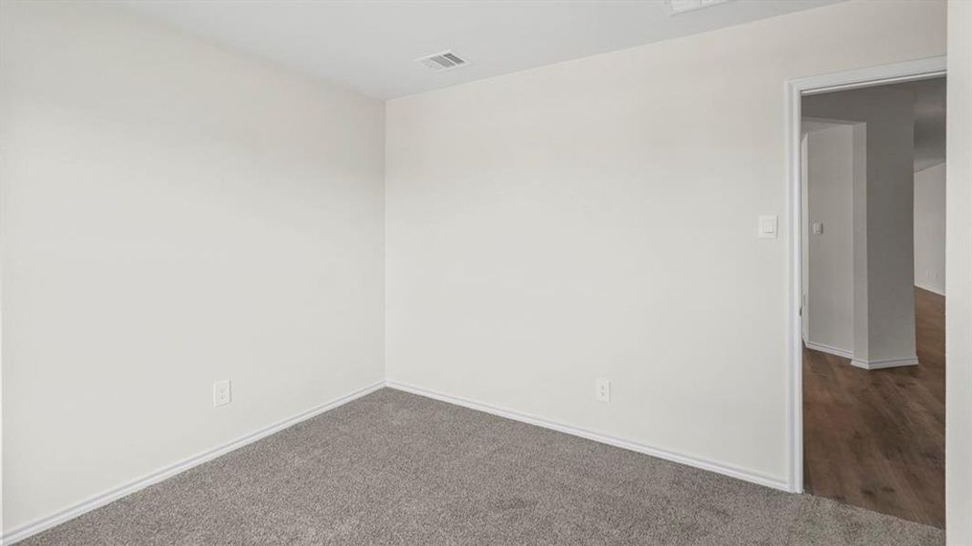 Unfurnished room featuring dark colored carpet and baseboards