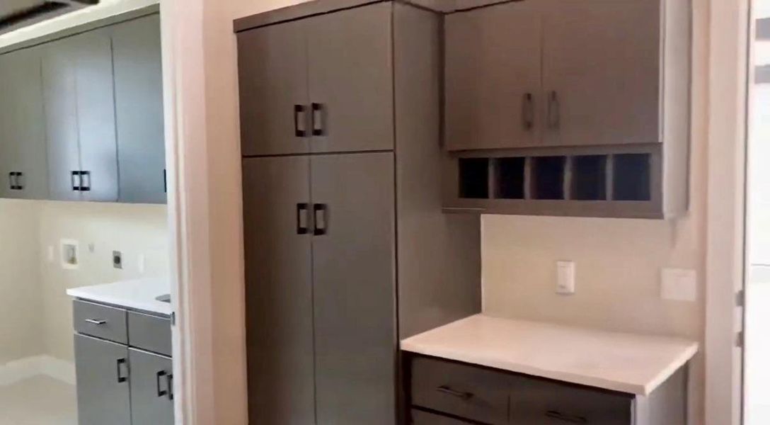 Kitchen with light countertops, gray cabinetry, and modern cabinets